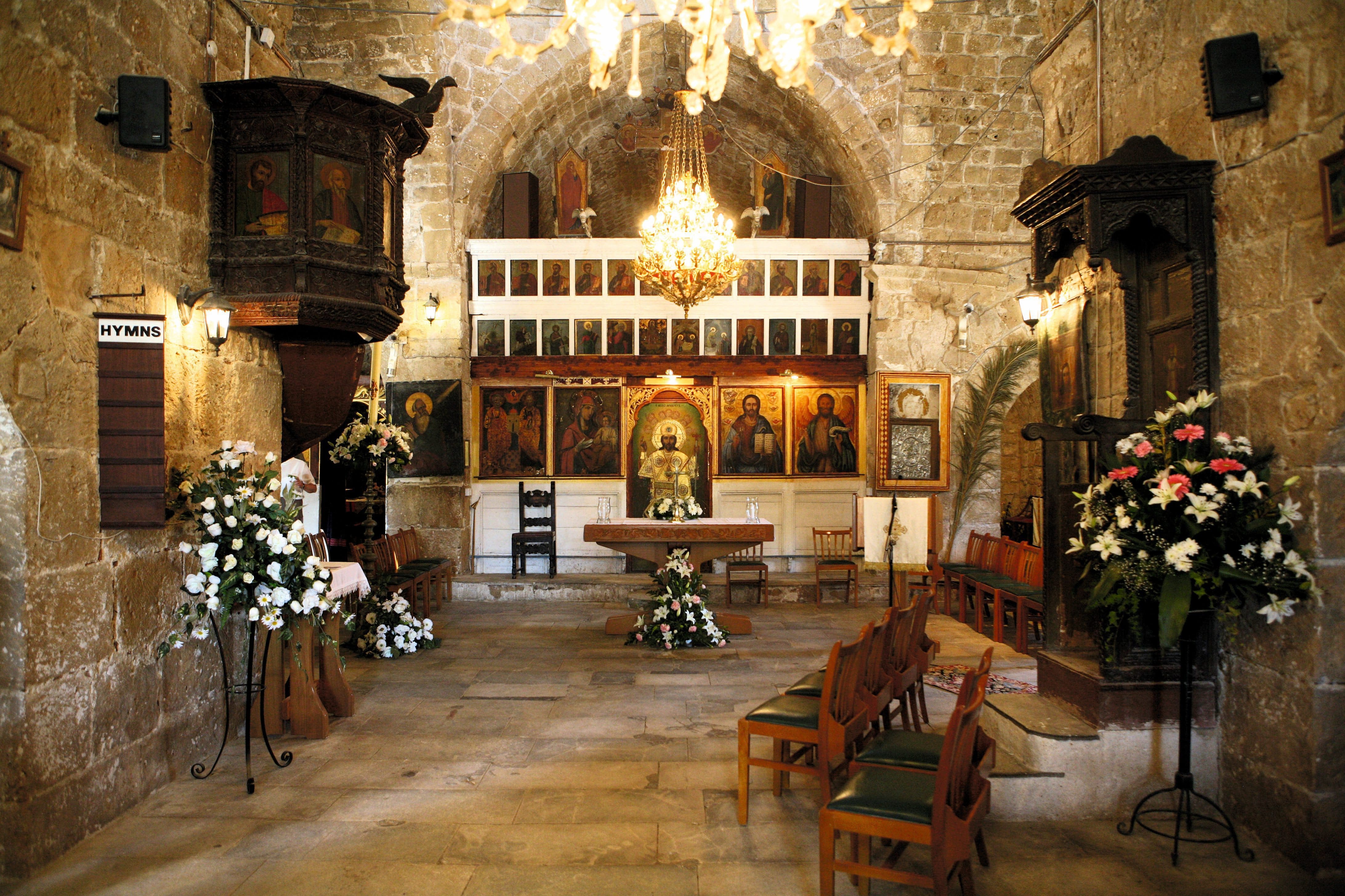 A more traditional setup, a 12th-century church is arranged for a wedding, with flowers and seating.