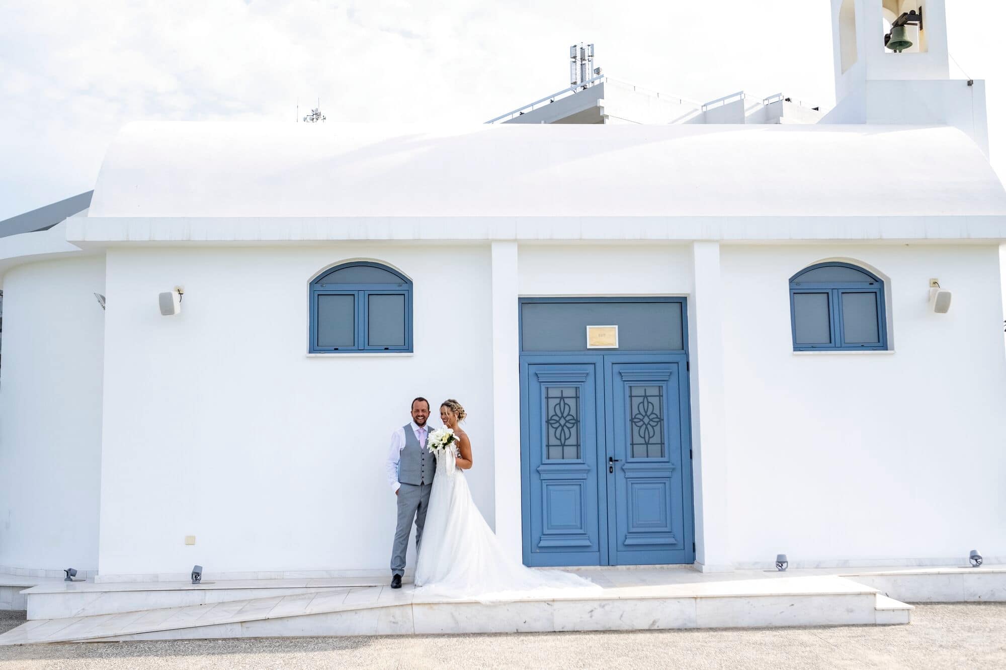 Bride and Groom standing outside a chapel.