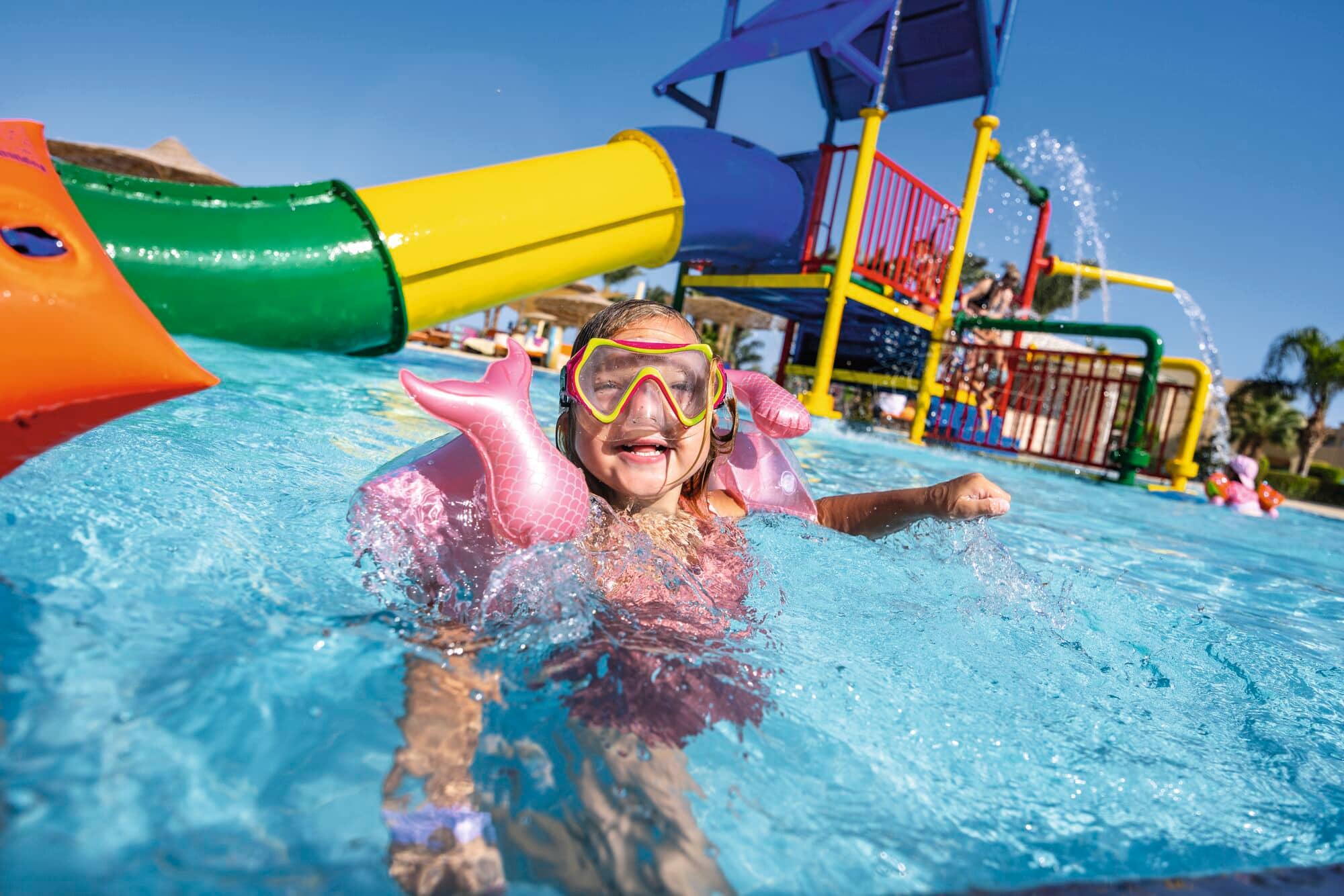A girl having fun and smiling in the pool.