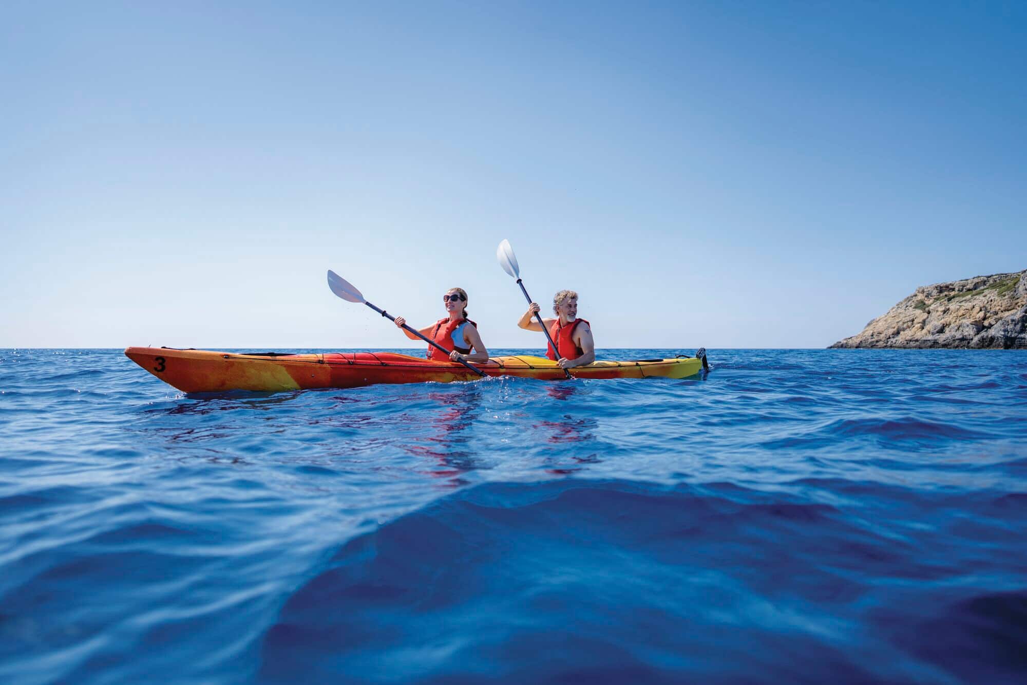 A couple kayaking in the sea.