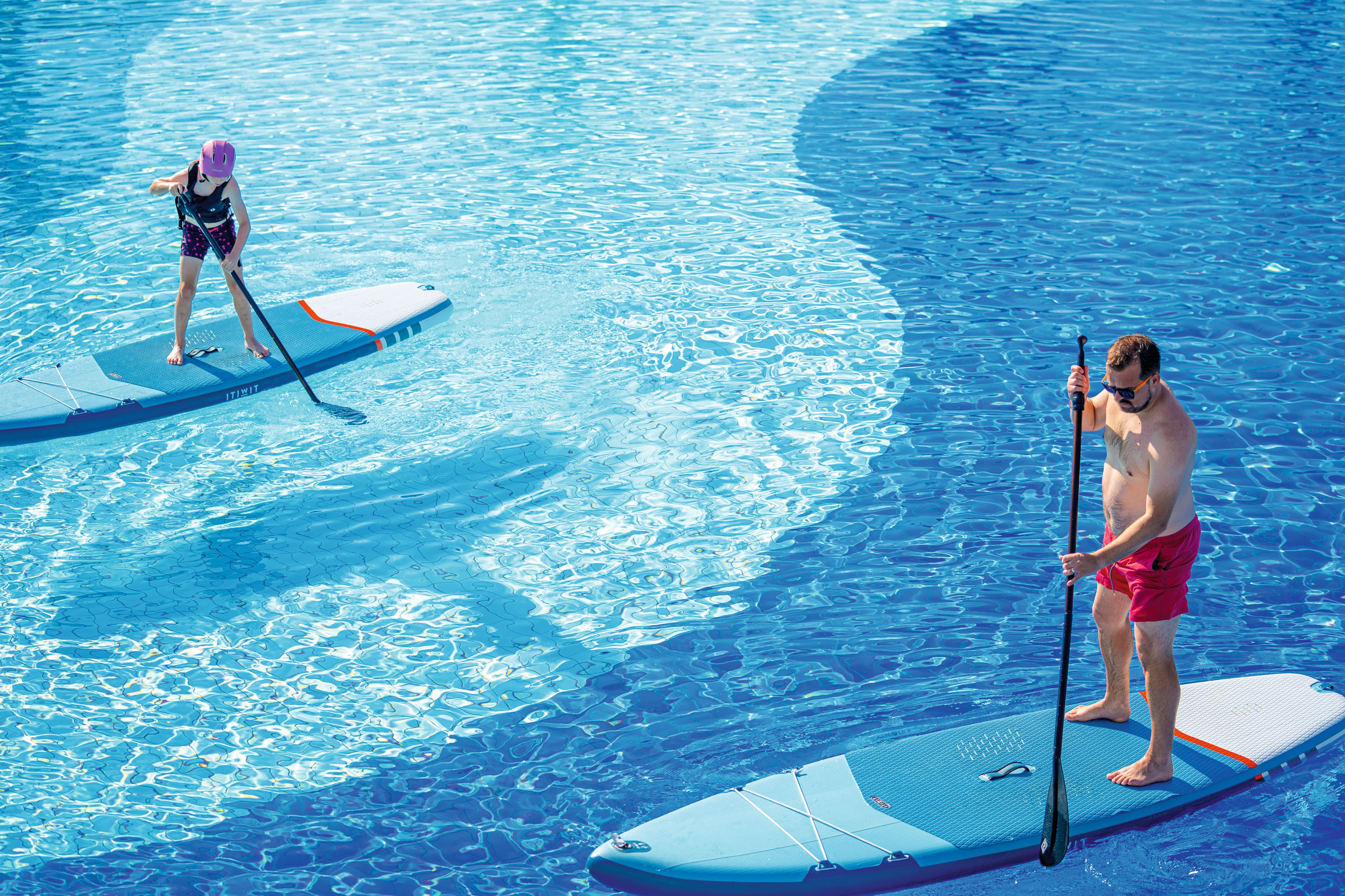 A family having fun on inflatable paddle boards.
