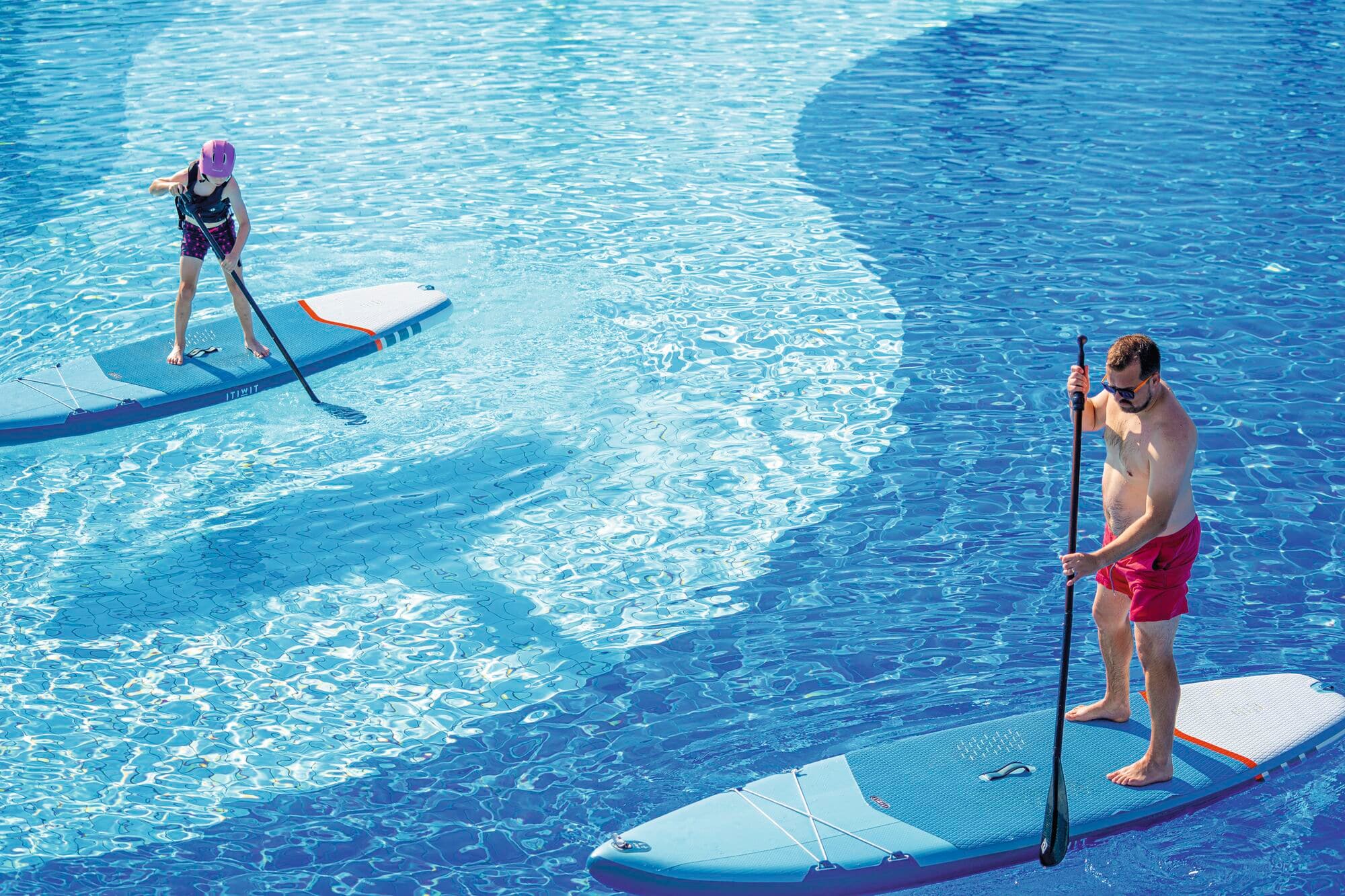 A family having fun on inflatable paddle boards.