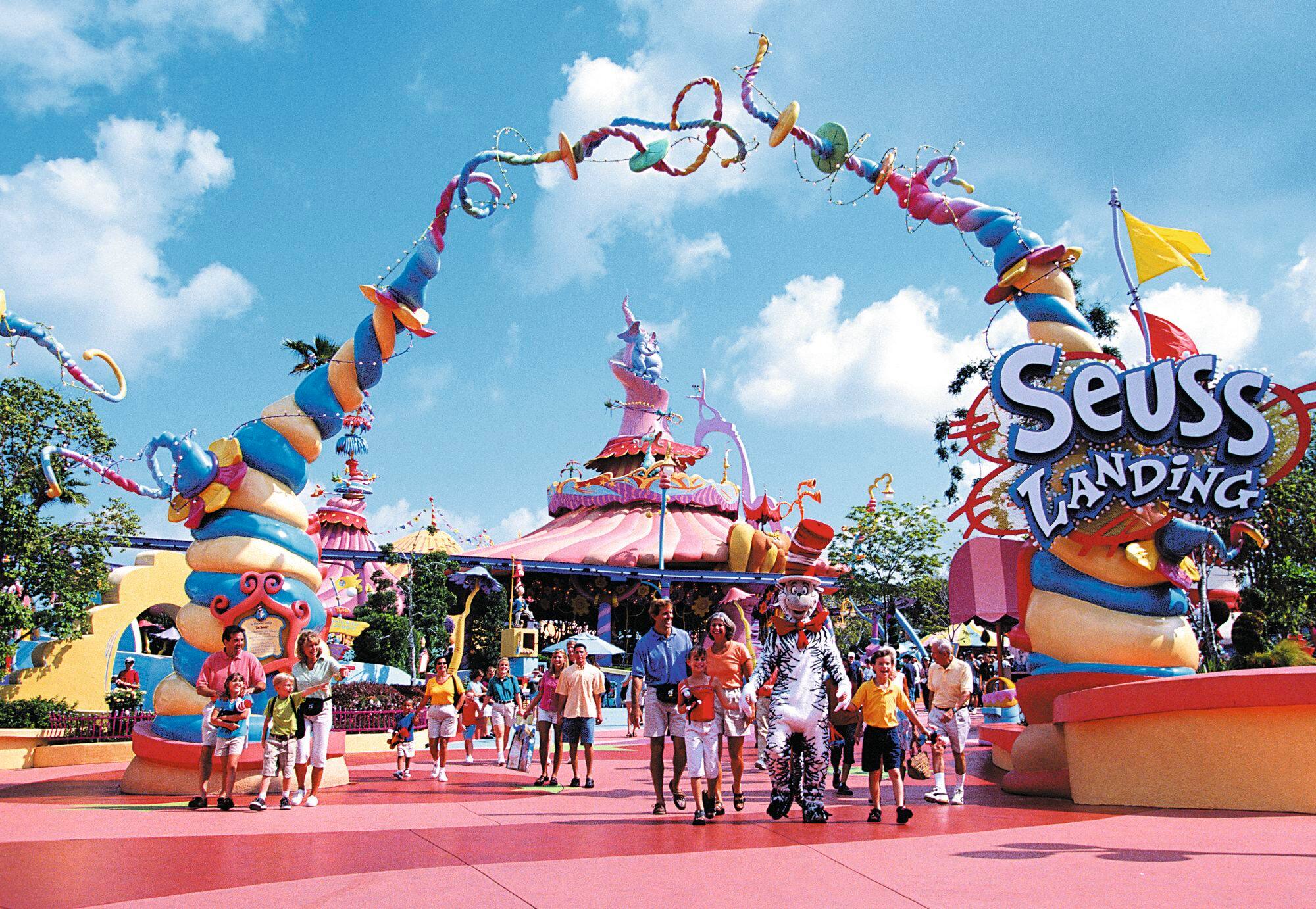 Entrance to Seuss Landing with colourful arch and people walking underneath.
