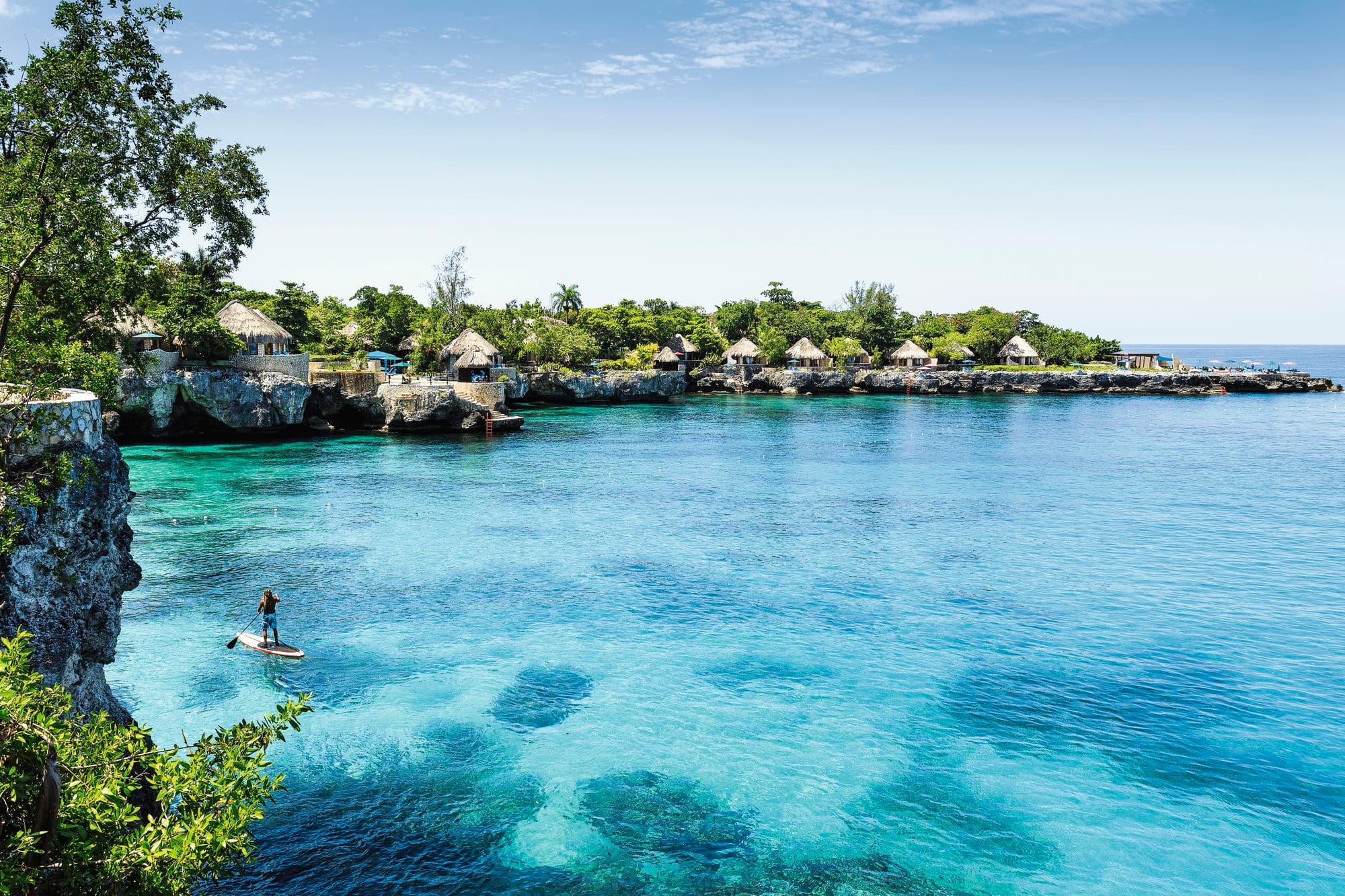 A person paddleboards around the coast by the parish of Westmoreland, Jamaica.