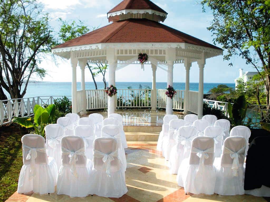 A wedding ceremony set-up in front of a hilltop gazebo overlooking the sea.