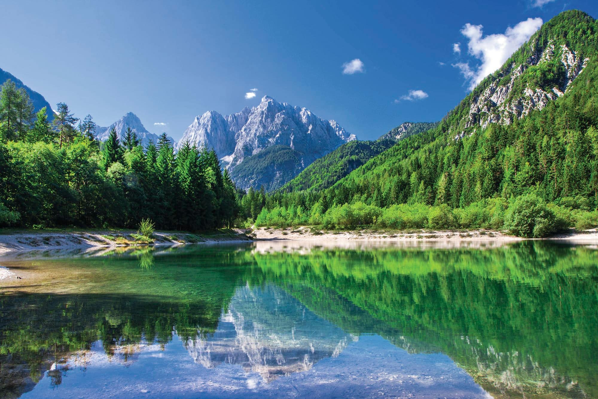 A blue lake with snow-topped mountains behind.