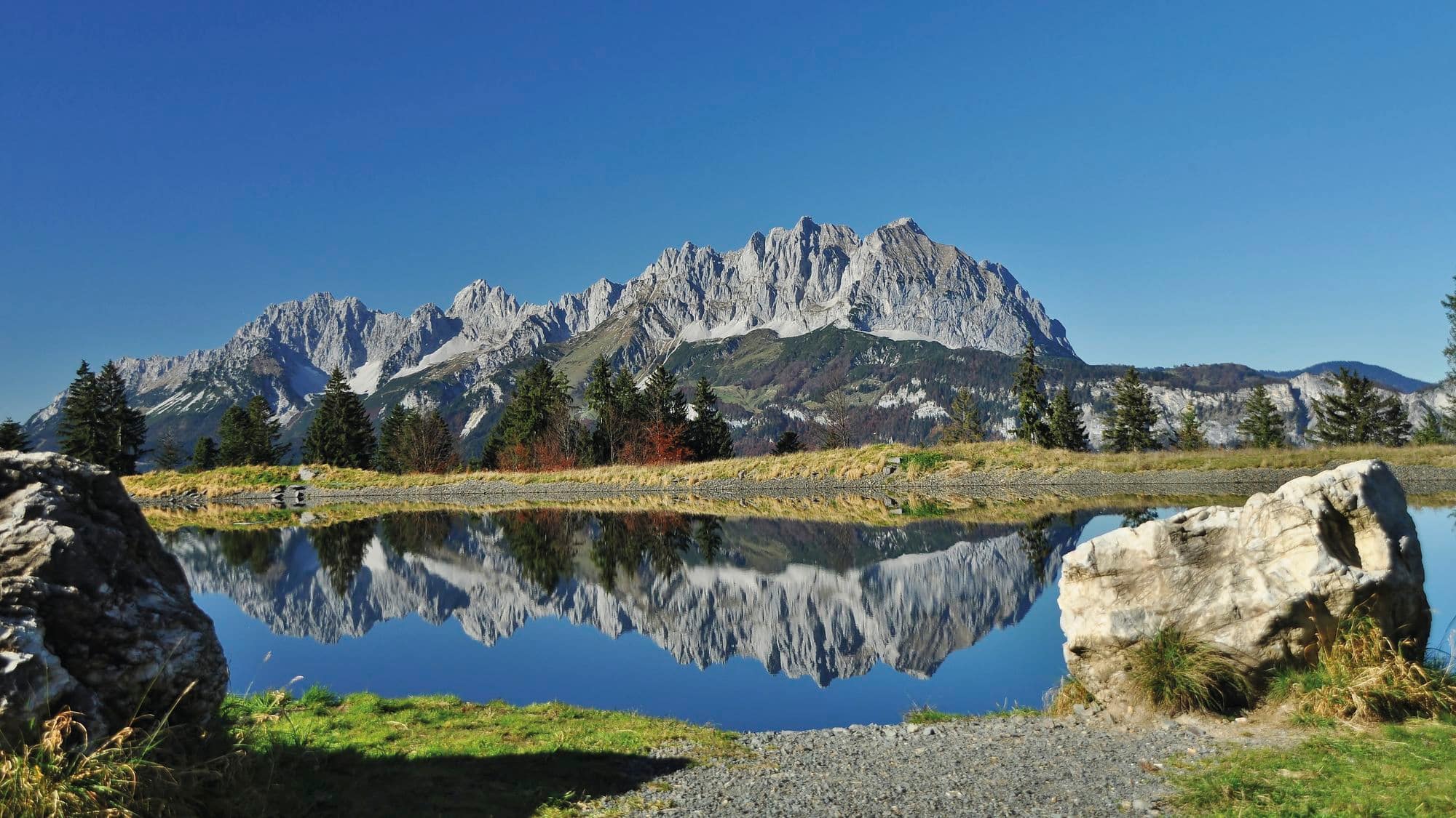 Lake in the mountains reflecting distant peaks. 