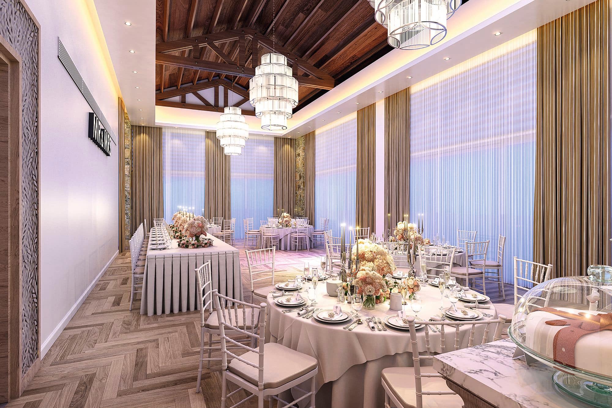 Art deco chandeliers hang above a sophisticated dining arrangement. Round tables surround the head table, with a wedding cake in the foreground.