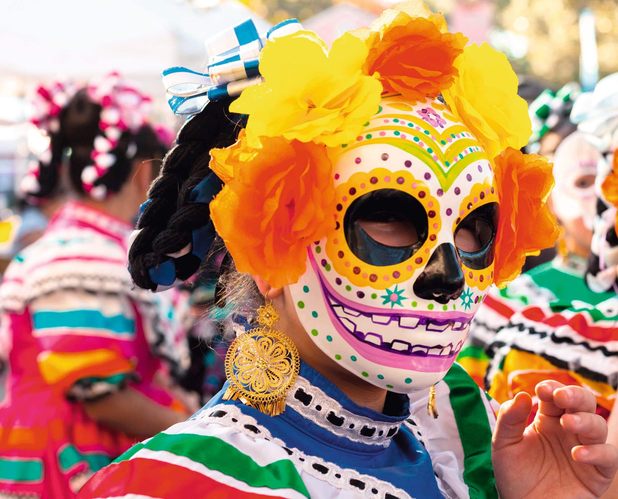 A festival-goer wearing a Day of the Dead style mask.