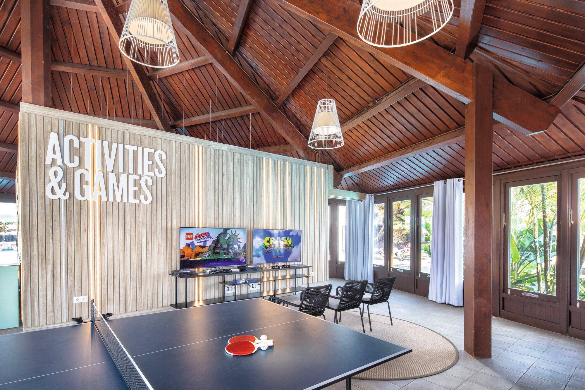 A games room with table tennis and game consoles. 