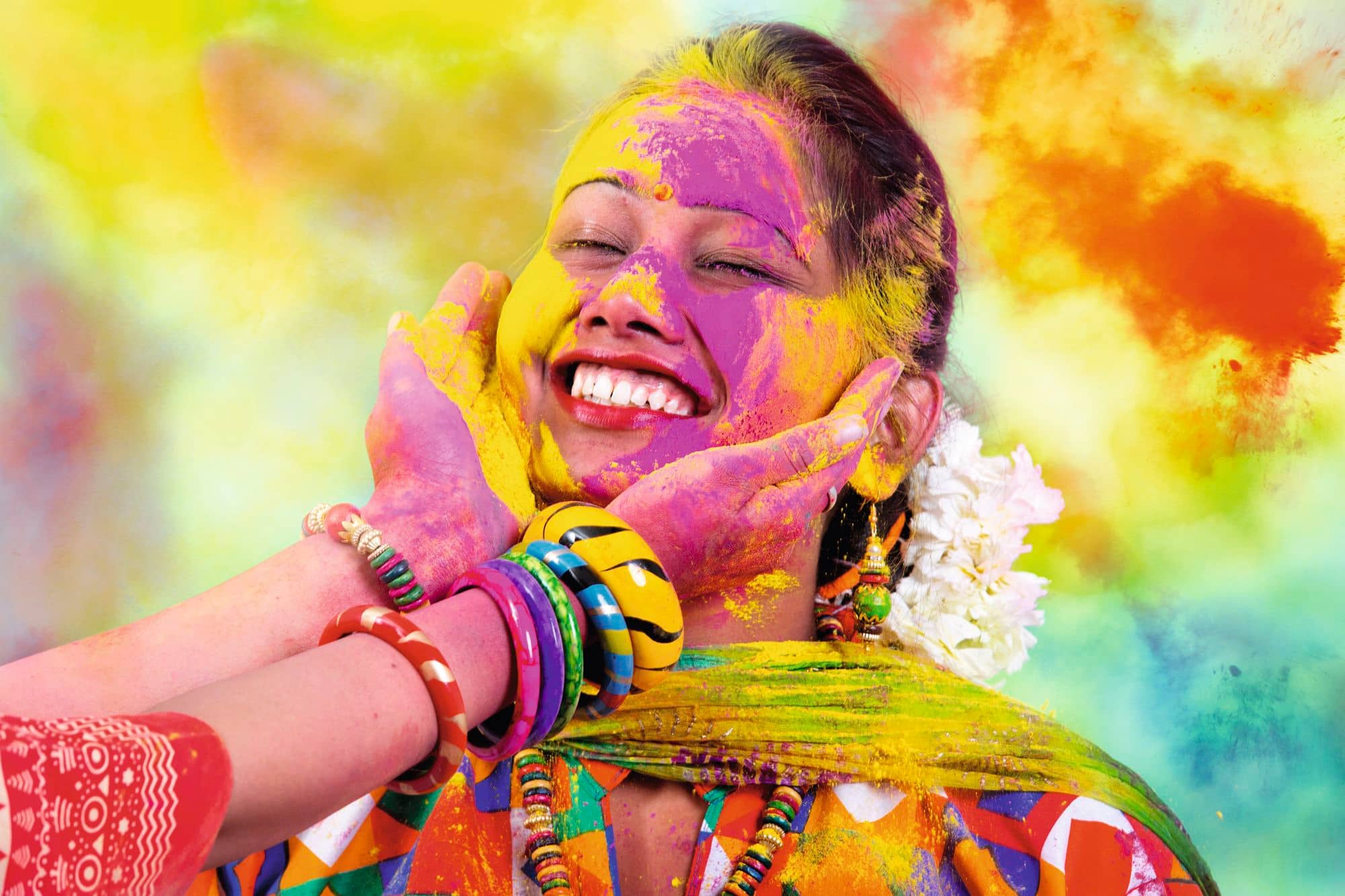 Person covered in colourful powder during a Holi festival celebration.