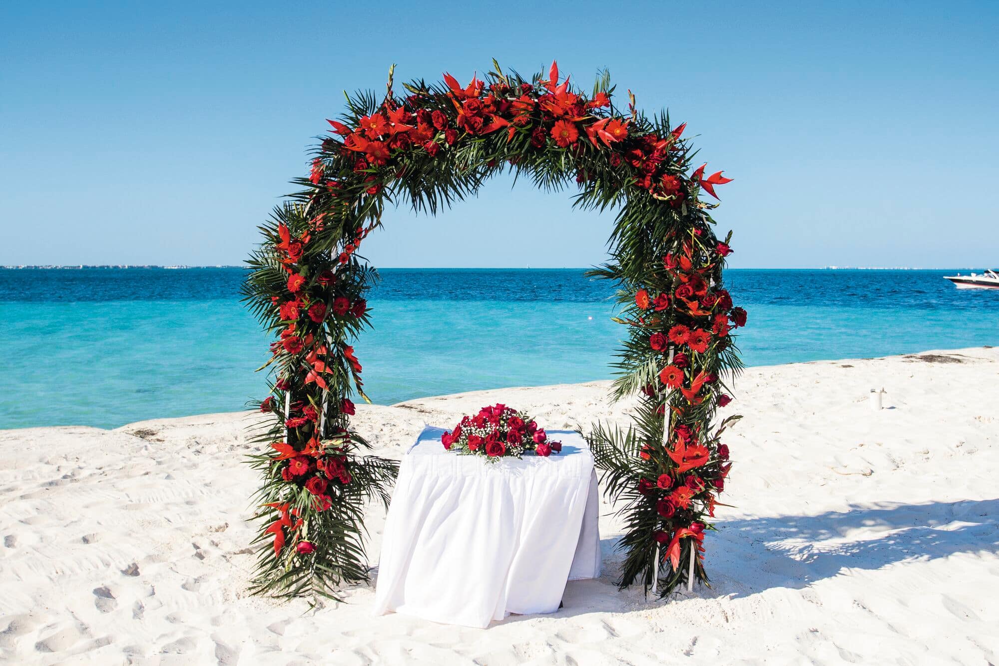A wedding set-up on a beach with a flower arch.