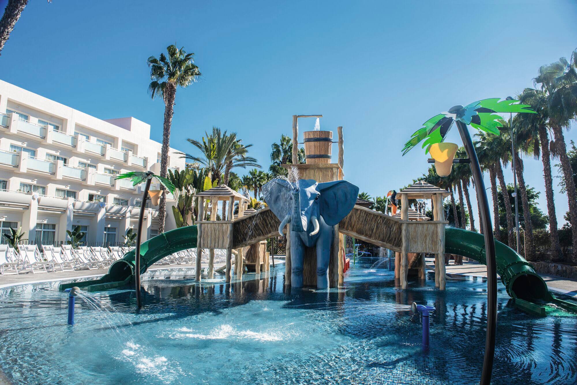 A jungle-themed splash park with mini slides and a tipping bucket.