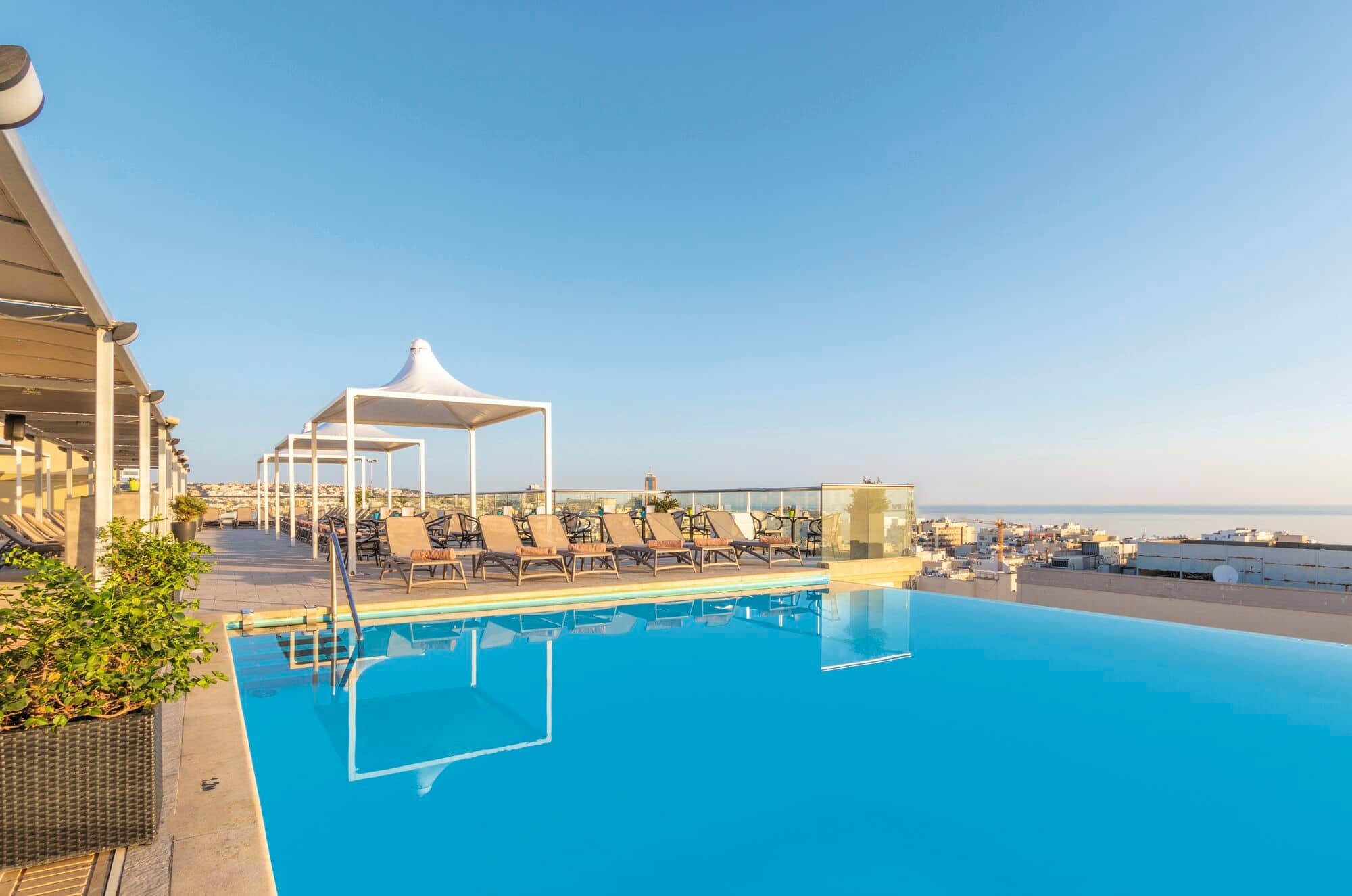A rooftop pool with a view of the sea.