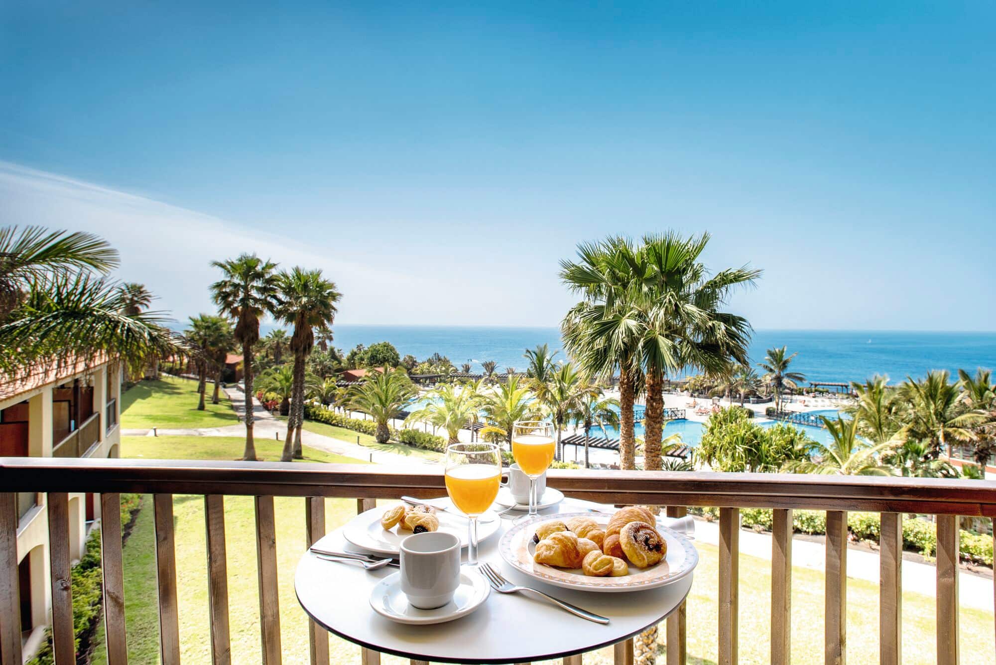 A Continental breakfast arranged on a table with a view of the sea.