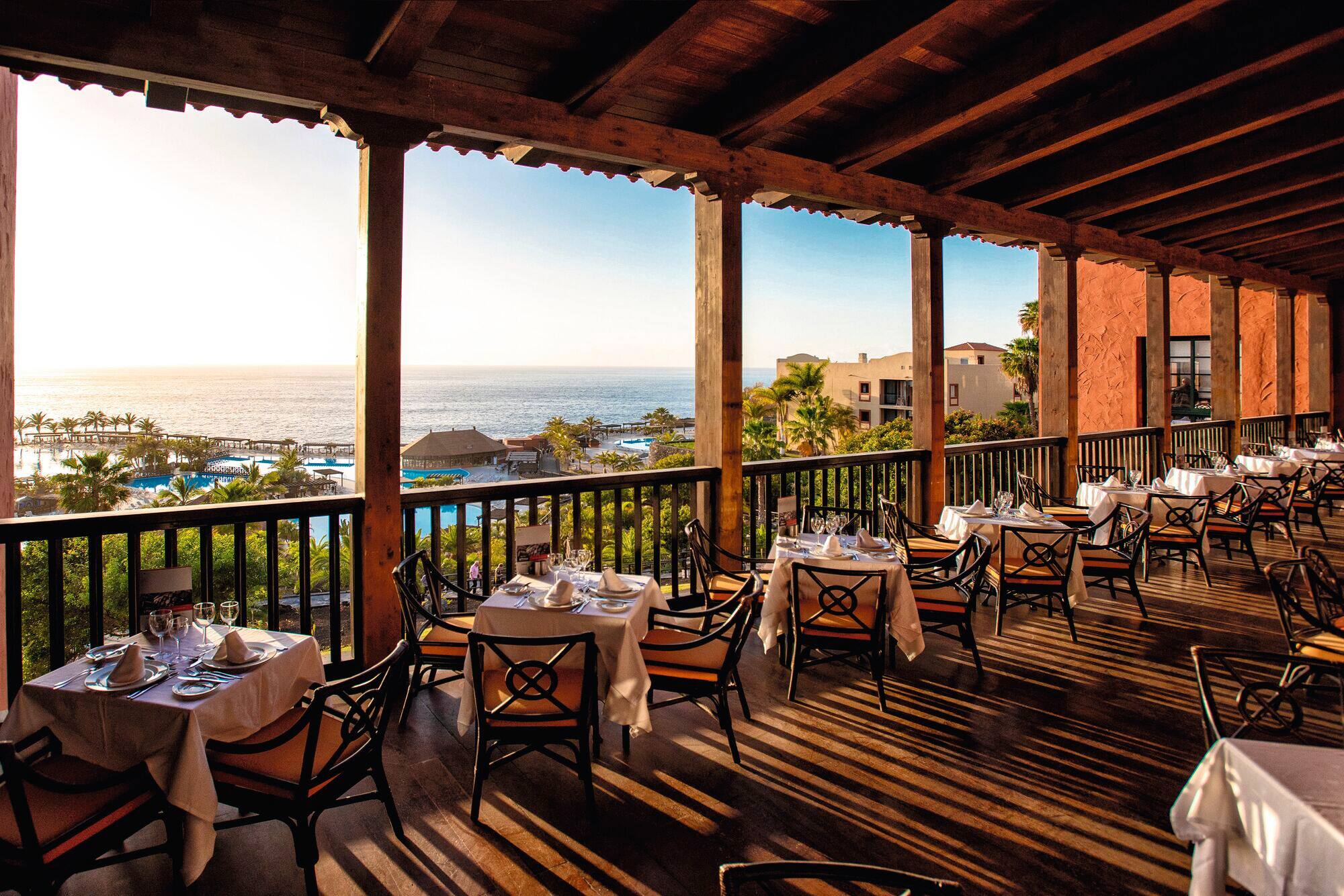 A dining area on a balcony overlooking the sea.