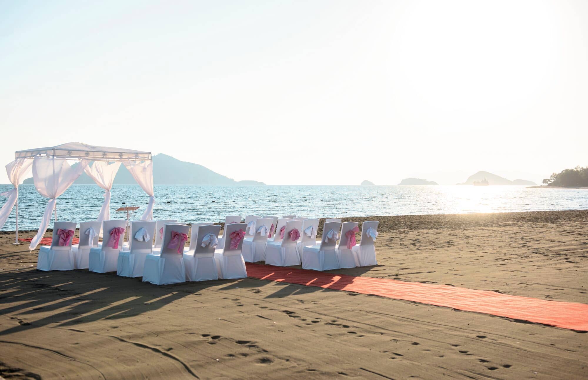 A beach wedding ceremony set-up looks out to the sea.
