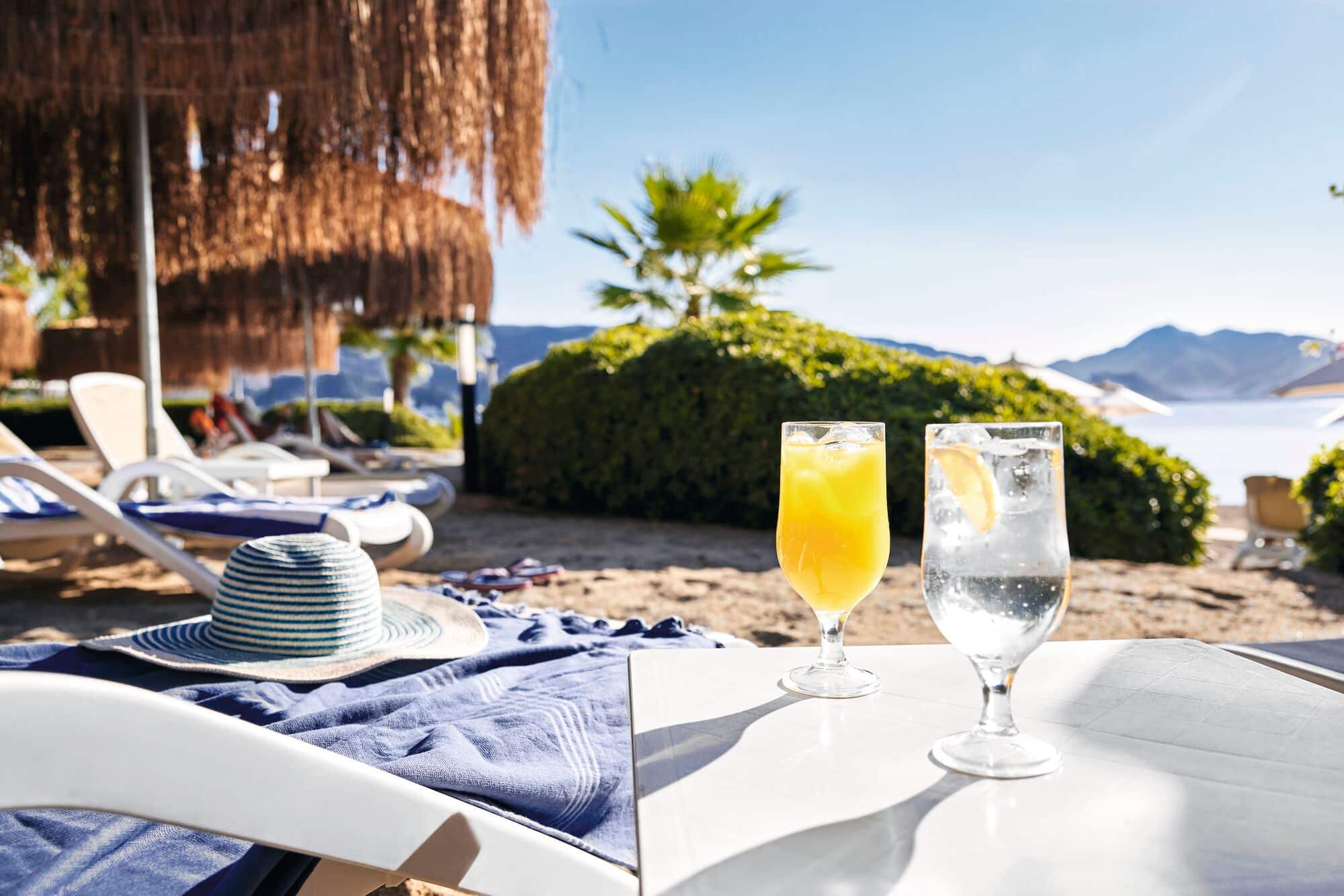 Two drinks on a beach table with sea view.