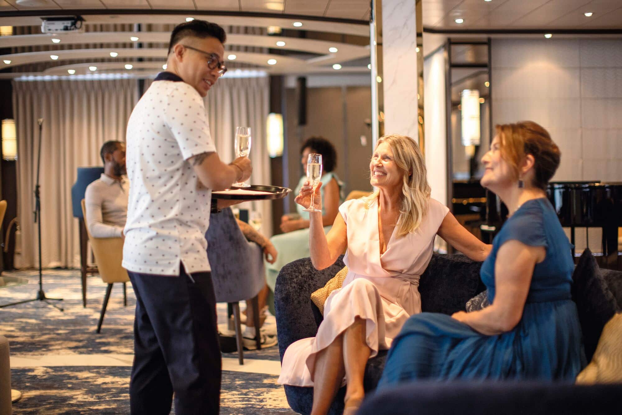 Friends being served a glass of prosecco onboard a TUI River cruise.