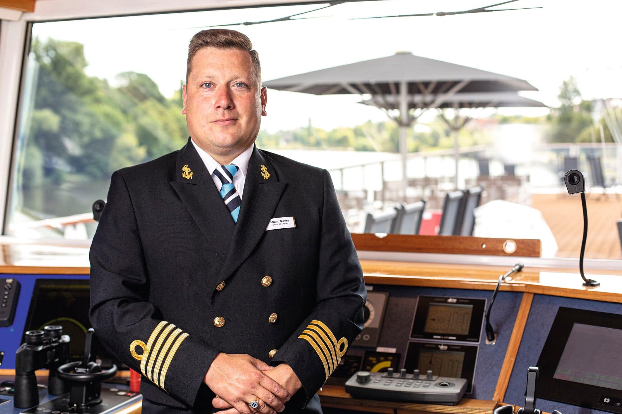 A headshot of a river cruise ship captain in the wheelhouse.
