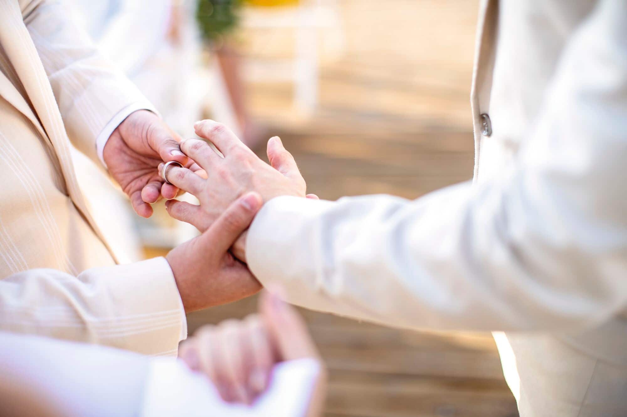 A close-up of two people exchanging rings during a ceremony.