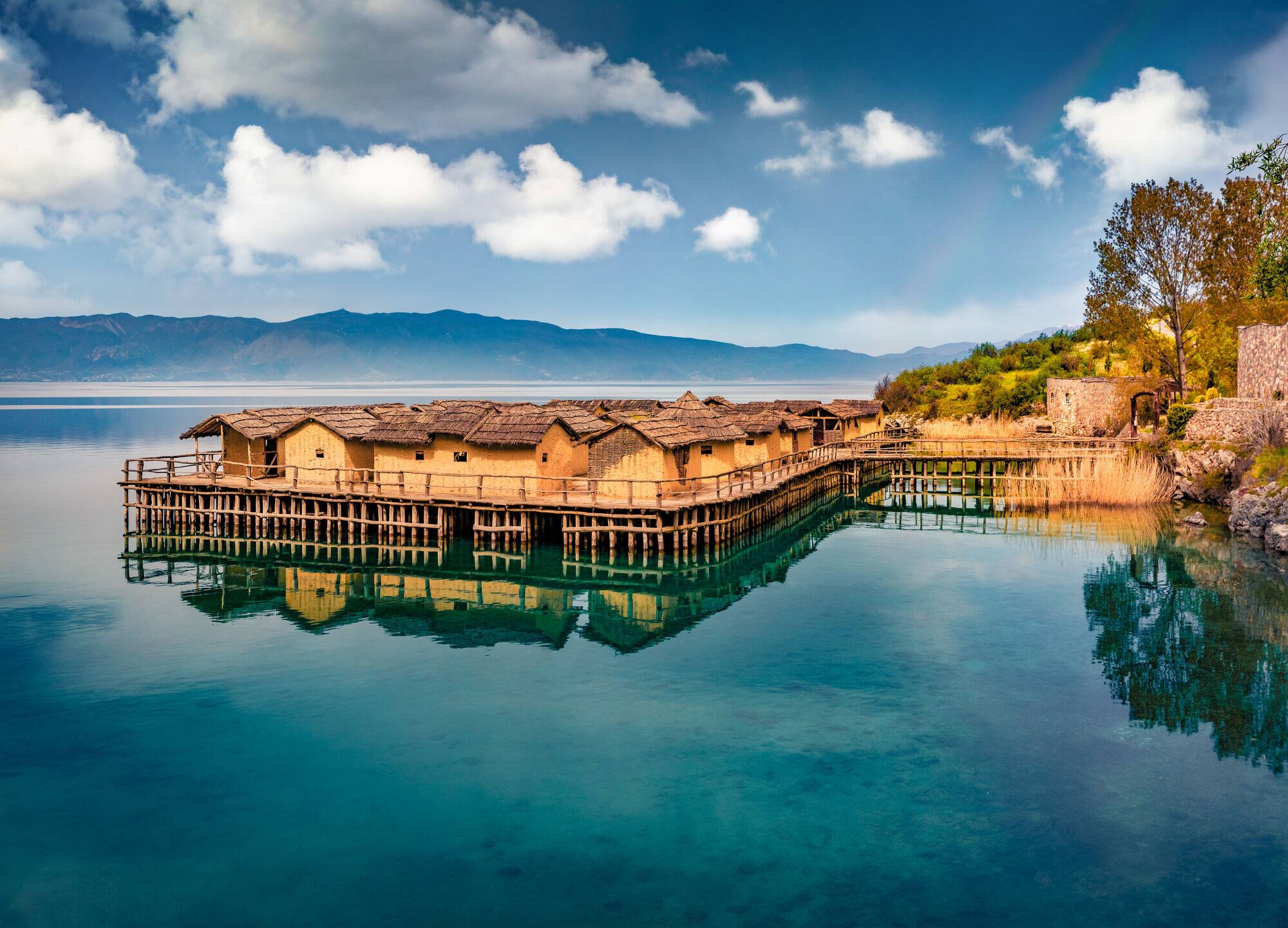 Mud huts stand on a platform built over Lake Ohrid. 