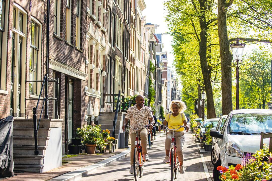 Couple exploring the streets of Amsterdam by bike