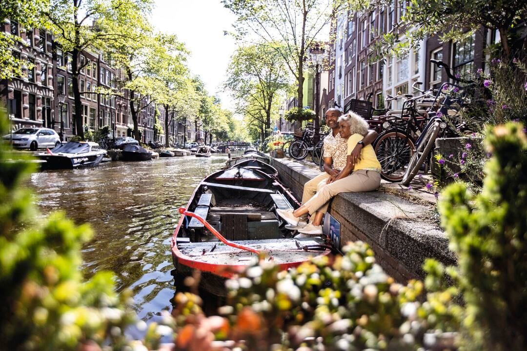 Couple taking in the views of the tall houses along the canals of Amsterdam
