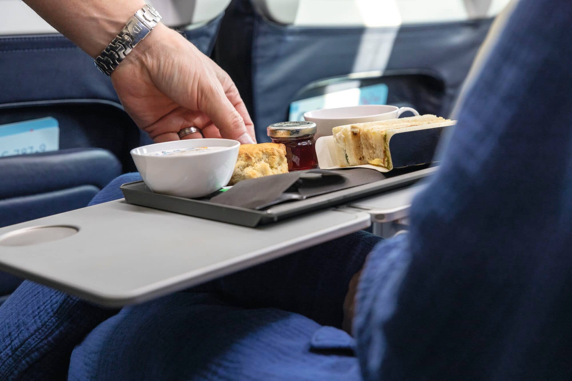 TUI cabin crew serving food to customers on board.