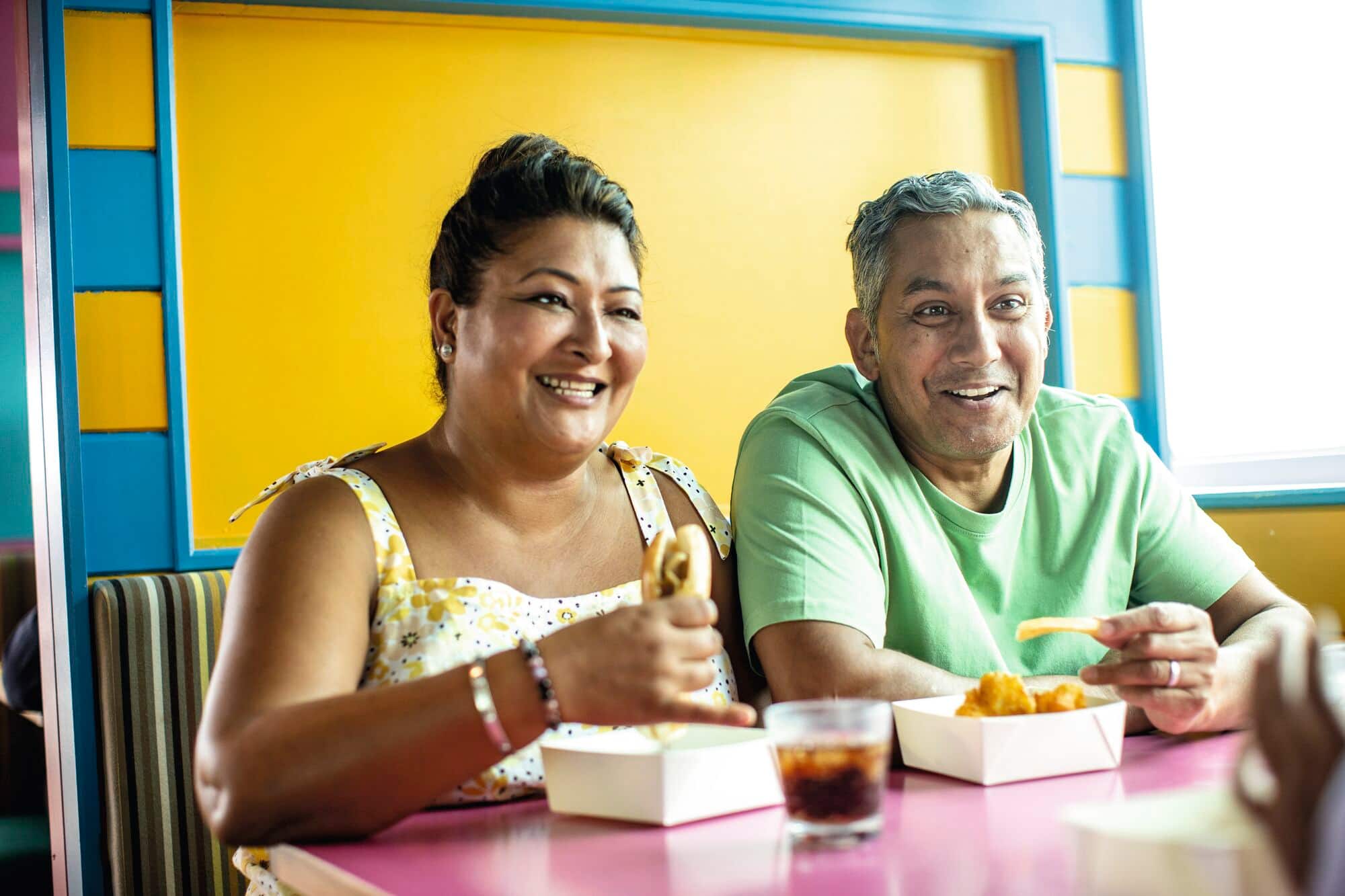 A couple eating chips at the snack bar.