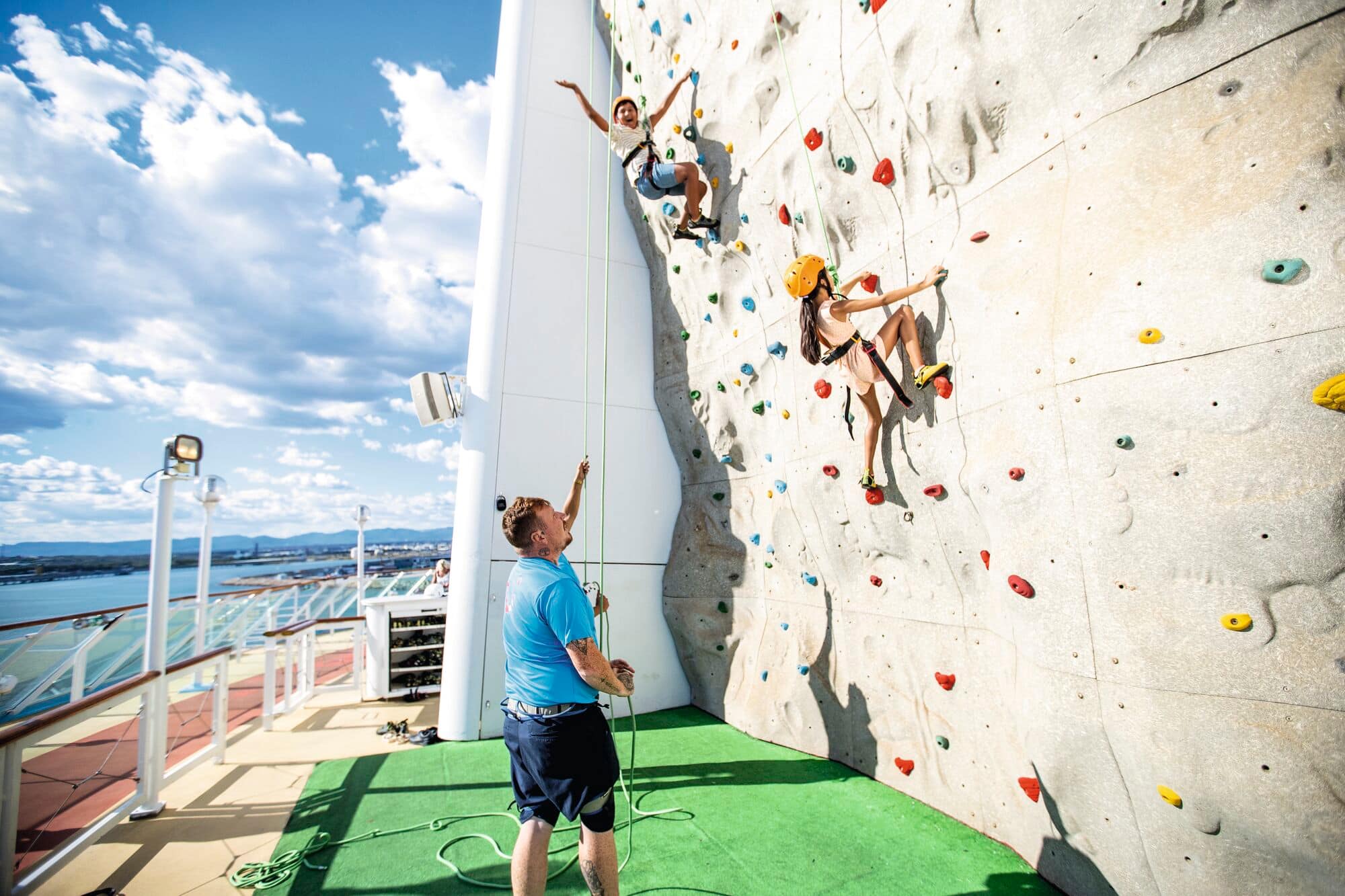 A child on a climbing wall on the ship deck.