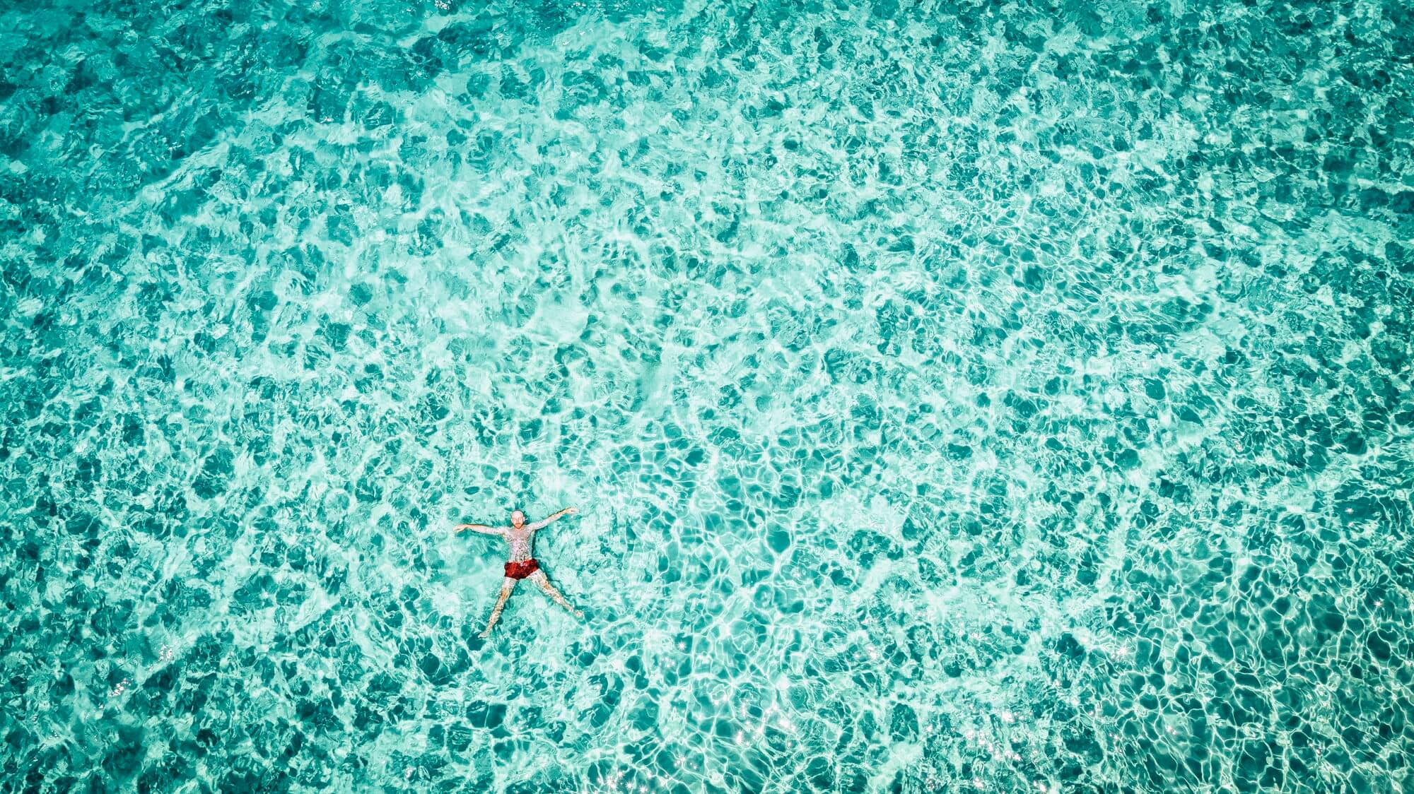 A man floating in a turquoise sea