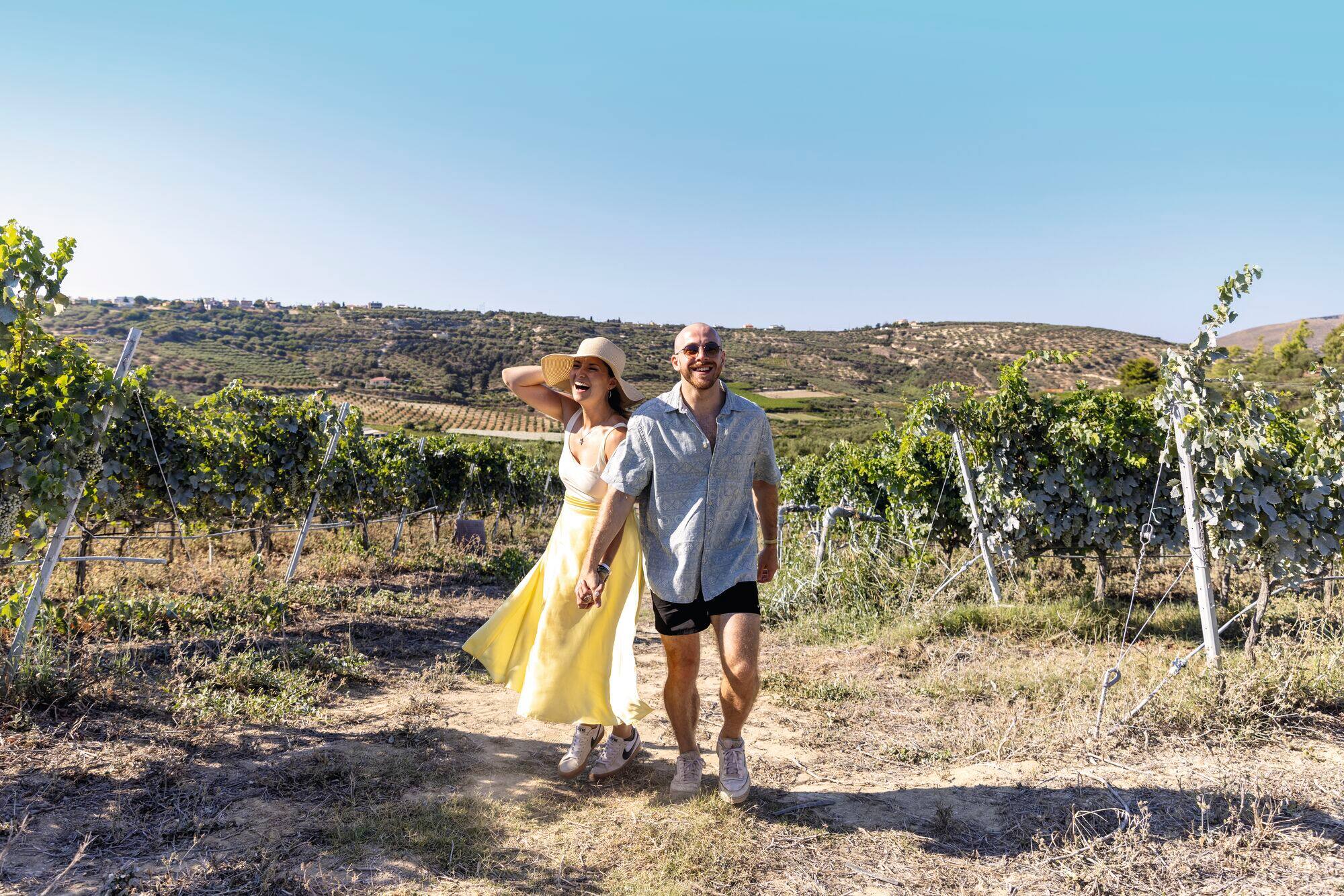 Couple walking through a vineyard.