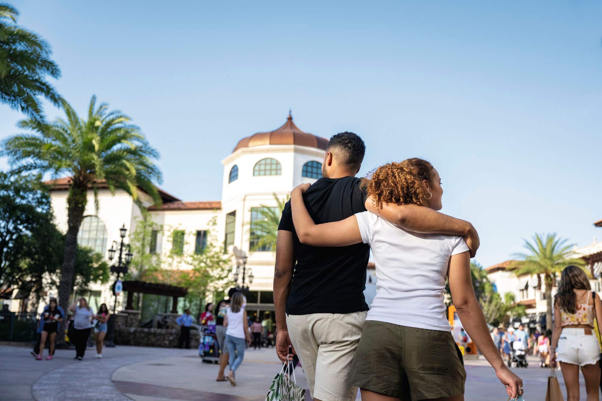 A couple walk around Disney Springs.