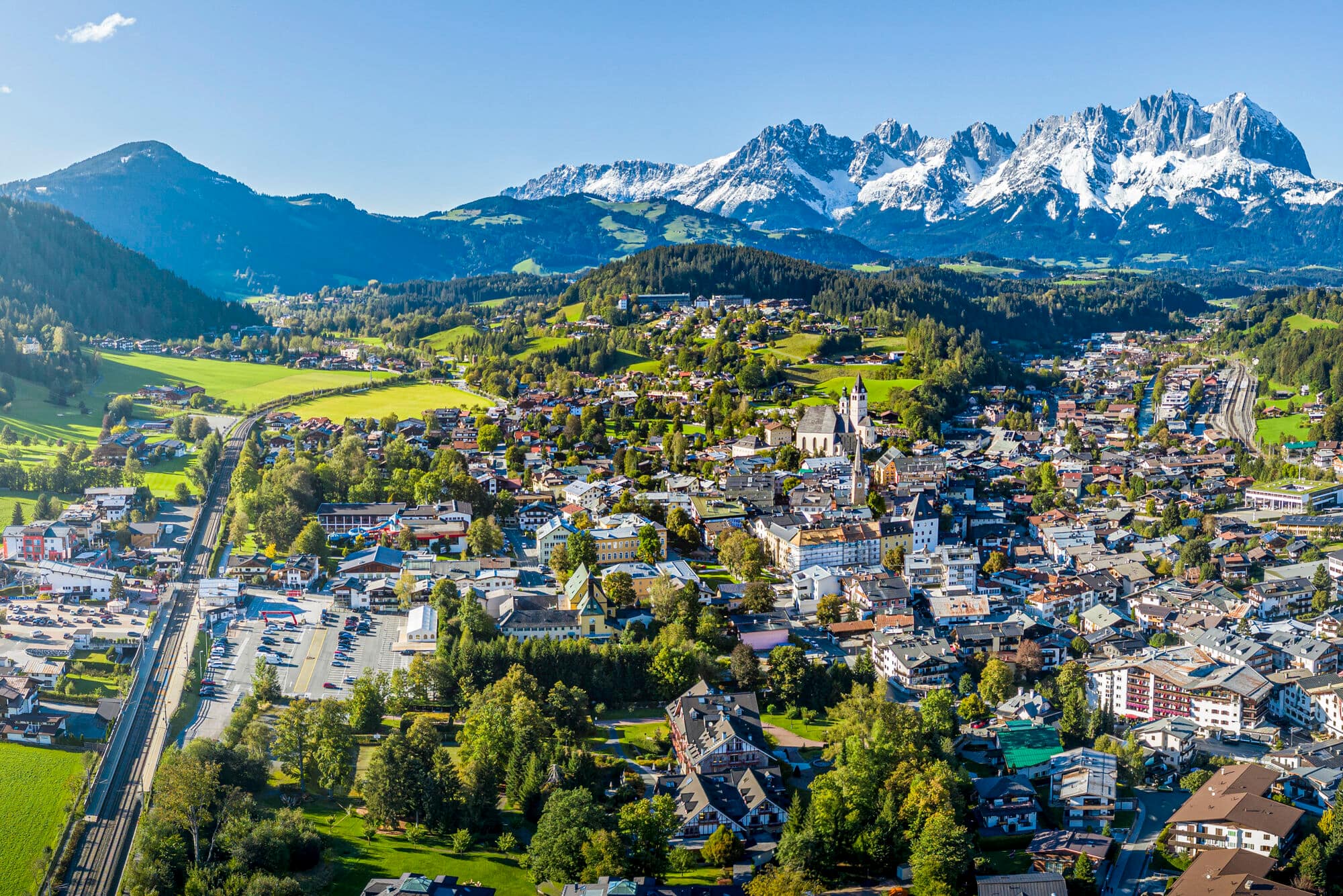 Aerial view of Kitzbuehel town. The church stands in the centre and clouds hang in the valley. 