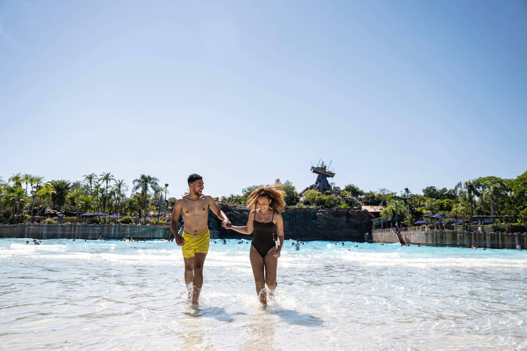 A couple walk on the beach at Typhoon Lagoon.