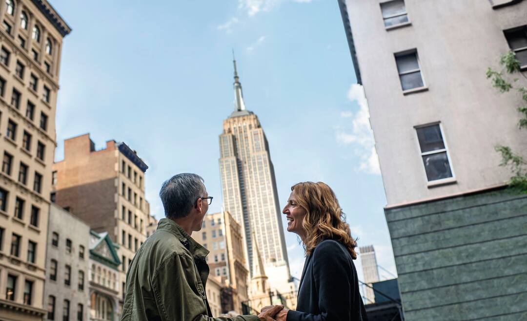 Couple looking up at the Empire State Building, New York City, USA