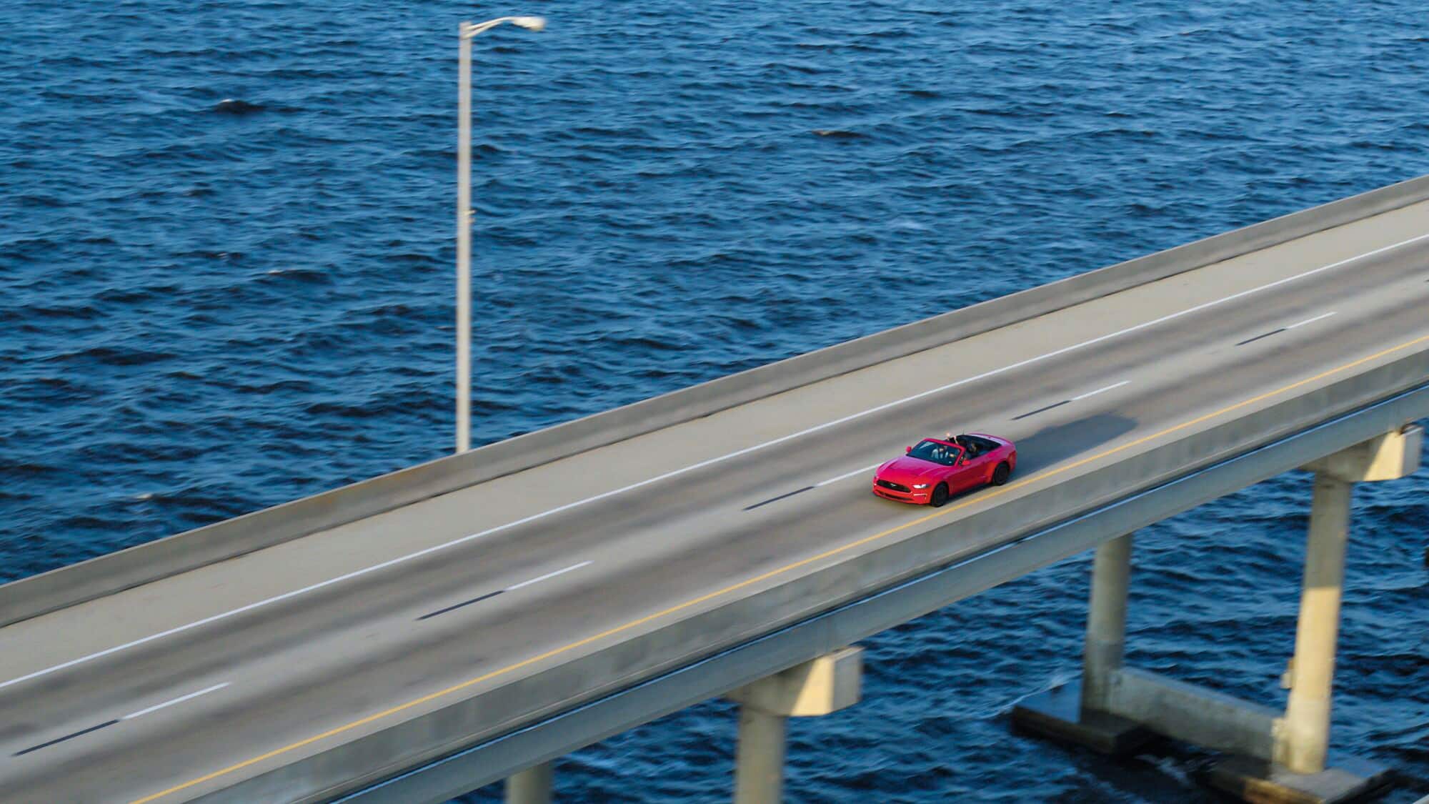 An aerial view of a car driving down the causeway.