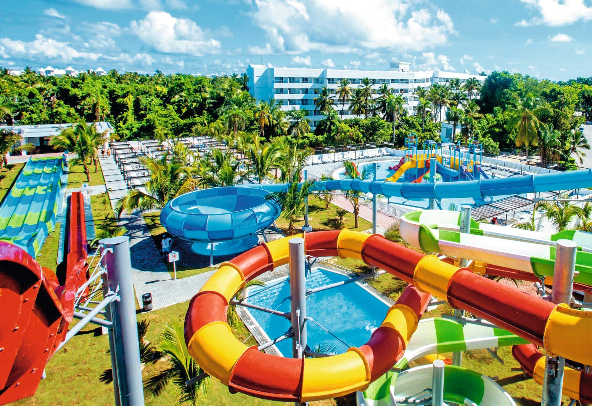 View over splash park with colourful striped water slides.