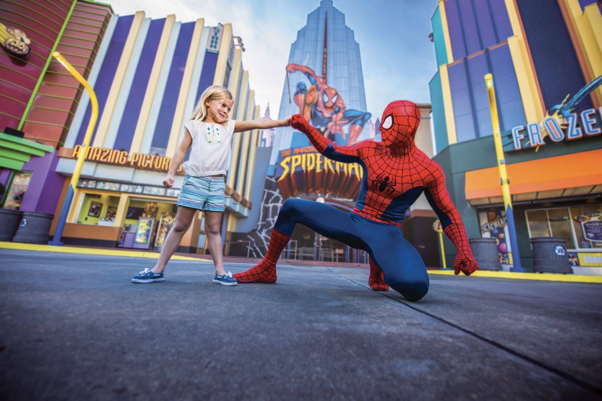 Spider-Man poses with child outside his ride – big smiles, bright colours and hero-sized fun.