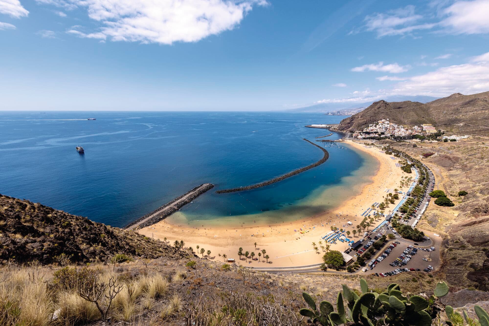 Aerial view of a beach with cliffs in the background.