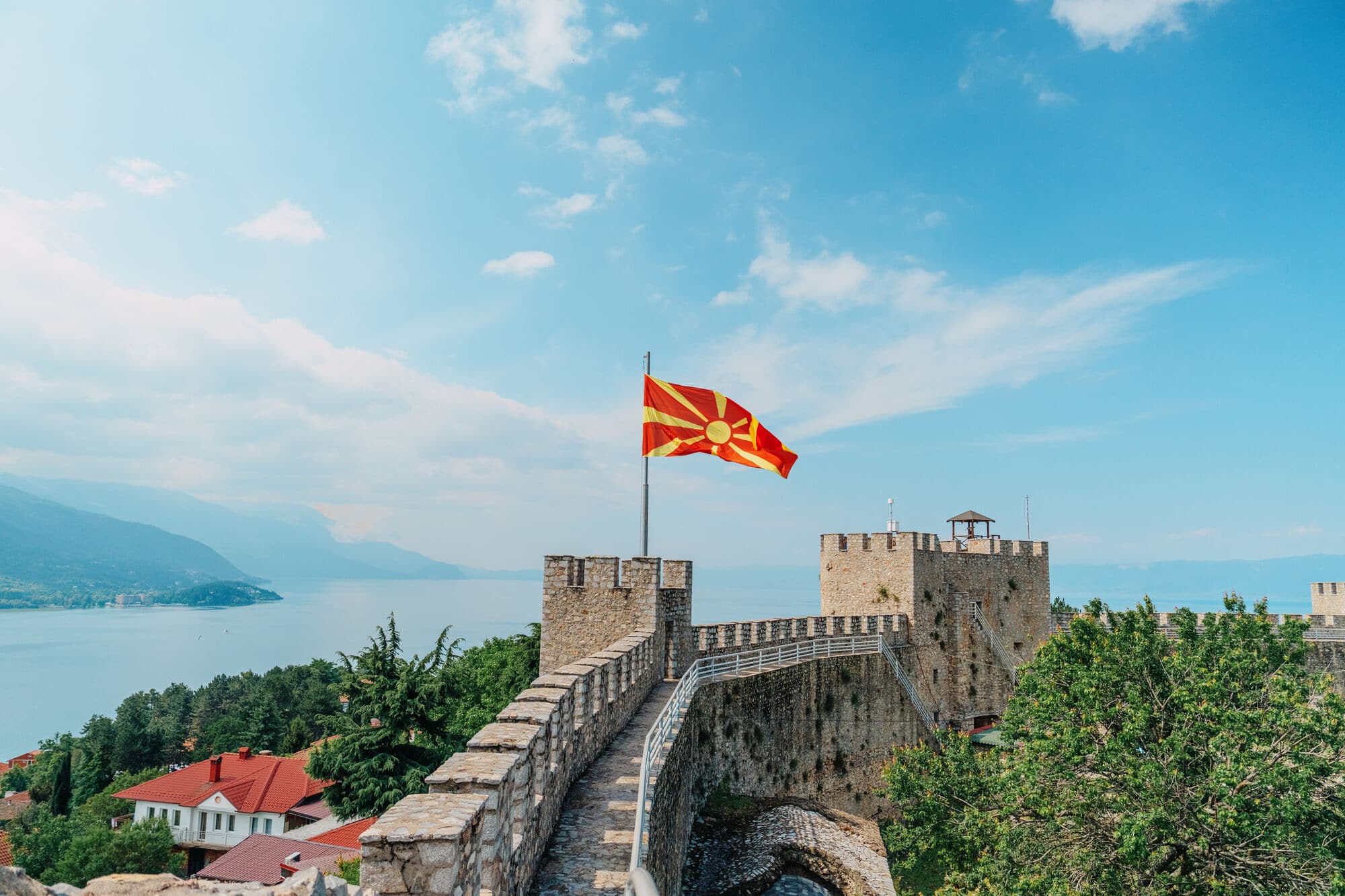 Castle walls in the centre of Ohrid Town. A flagpole with a large North Macedonia flag is on one of the towers. 