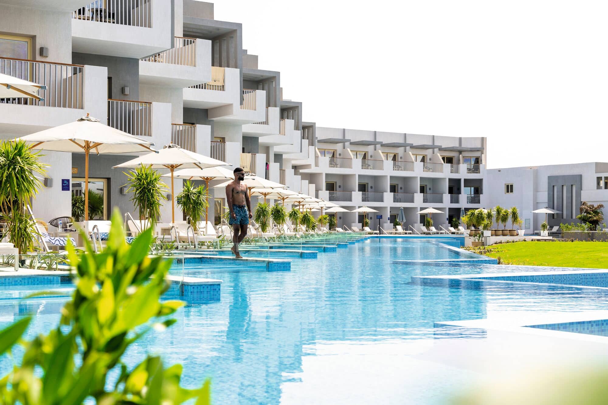A person standing on the terrace of a swim-up suite.
