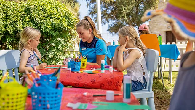 Children doing crafts at a colourful table.