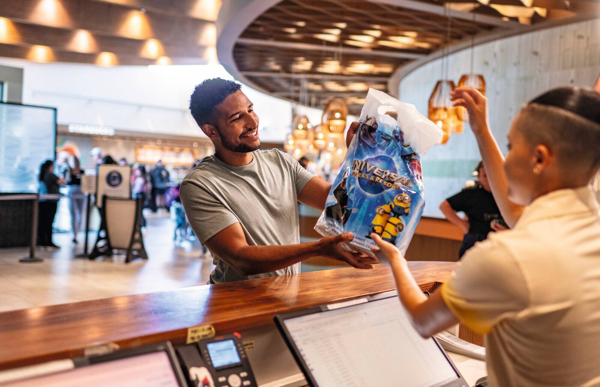 A man collecting his souvenirs from the hotel reception.
