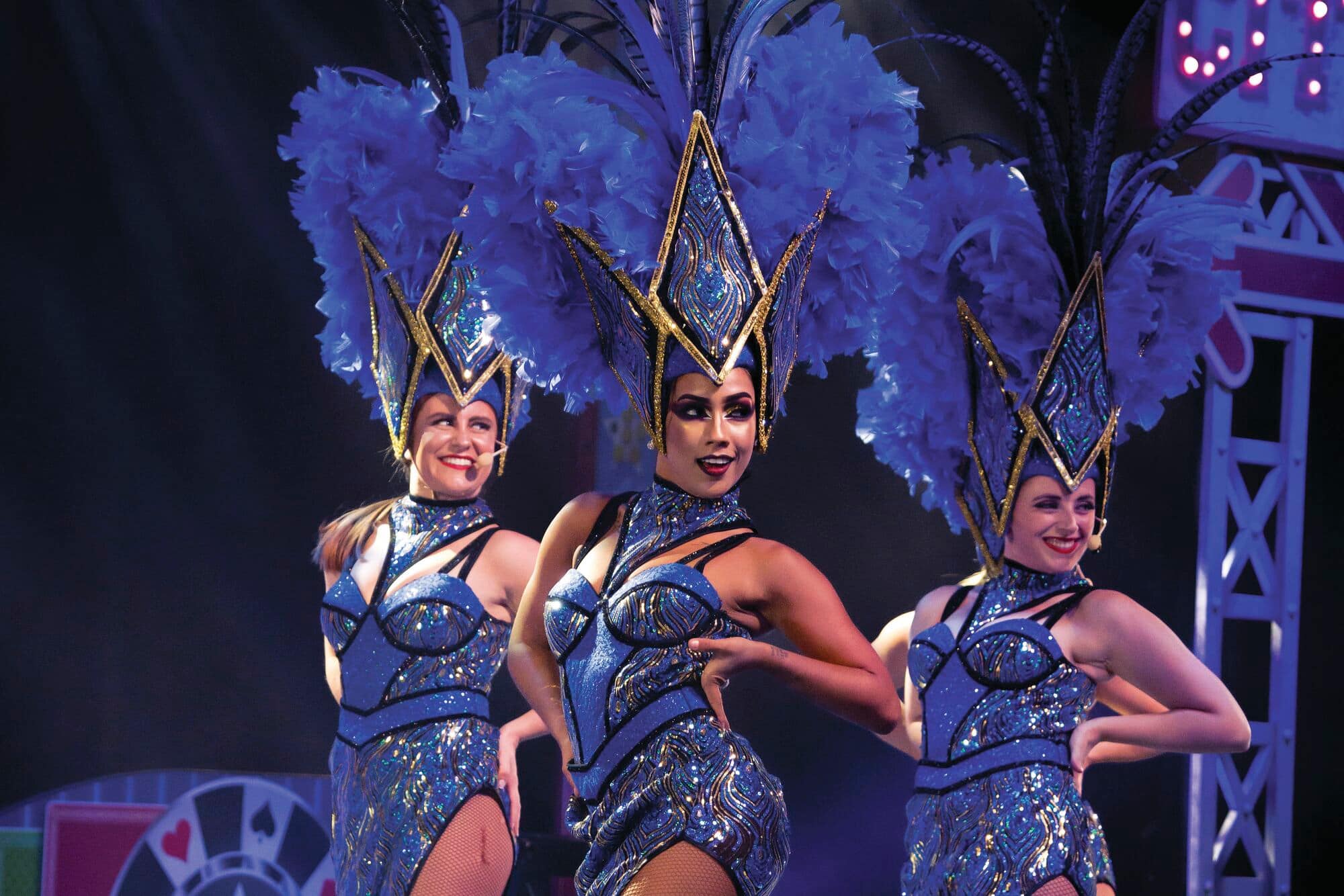 Performers in glittery clothing dancing on stage.