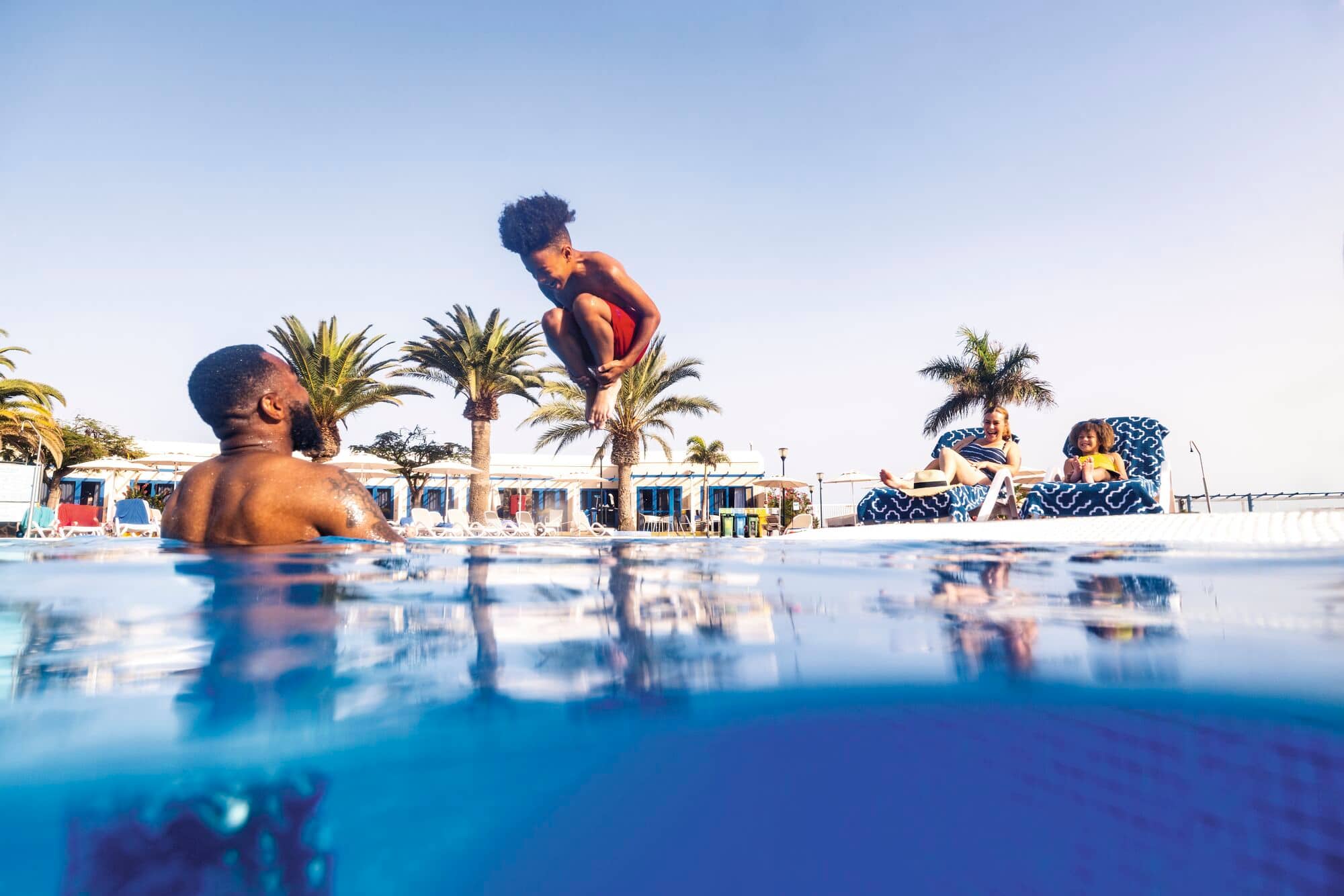 A child diving into a hotel pool.