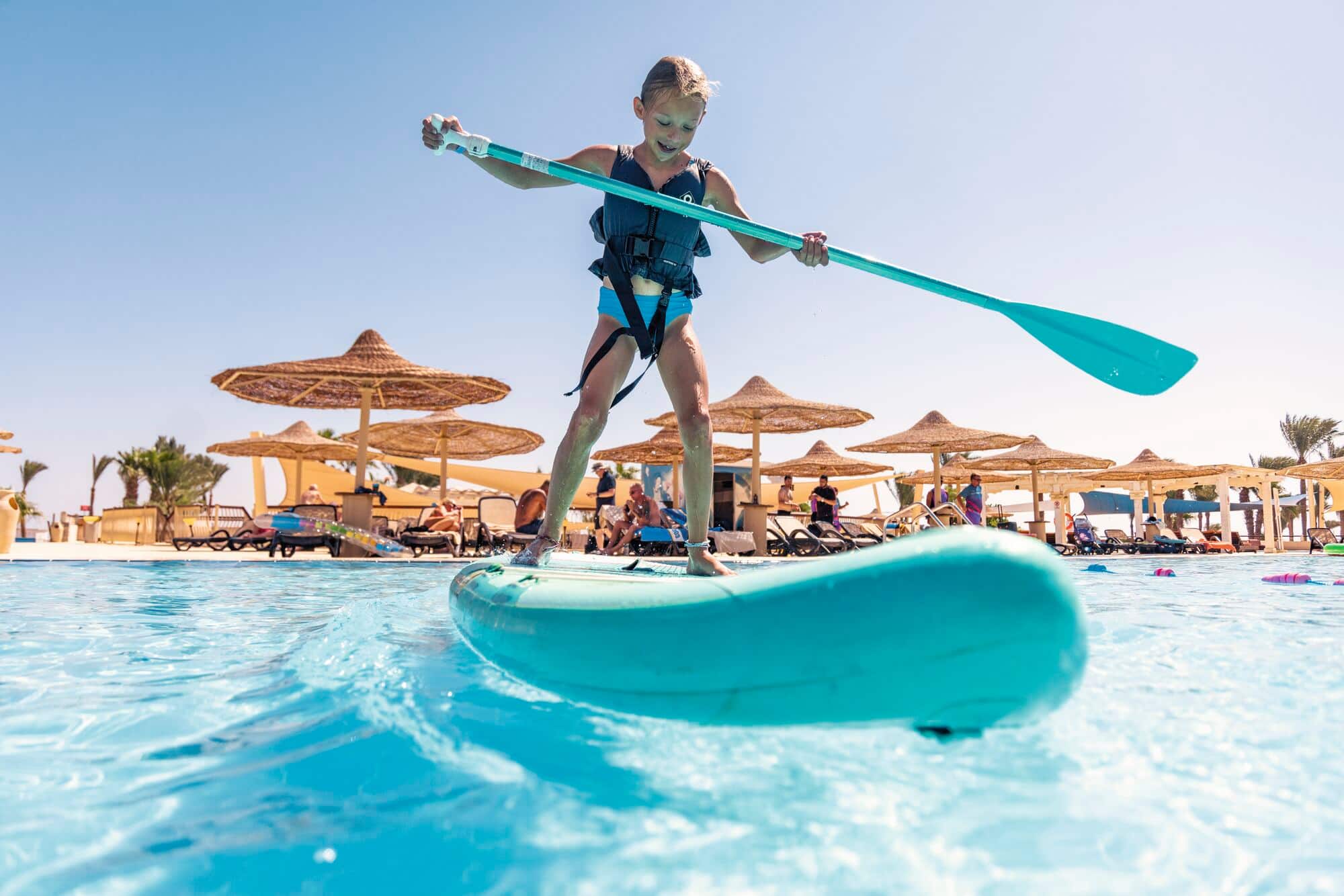 A child taking part in stand up paddle boarding.