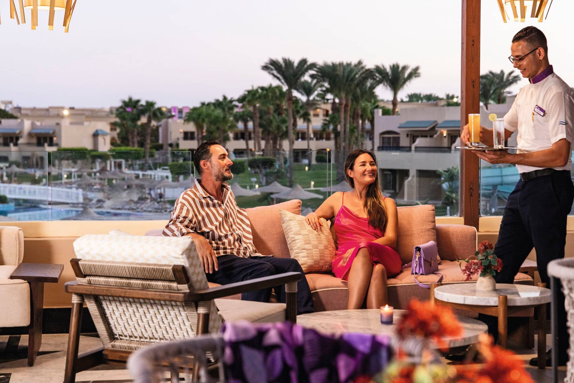 A couple being served cocktails.