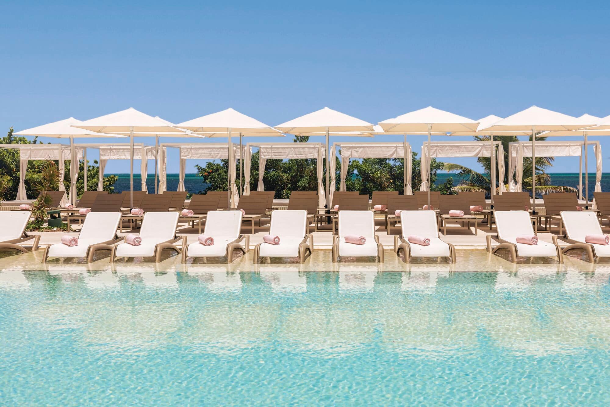 Relaxing pool side with sunbeds.